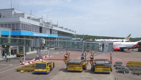 The terminal building at Entebbe International Airport, with a jet bridge extended to an Ethiopian Airlines aircraft and a Kenya Airways plane parked at an adjacent gate