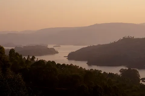 Golden-hour view over Lake Bunyonyi's terraced hills and forested islands from an elevated lakeside viewpoint